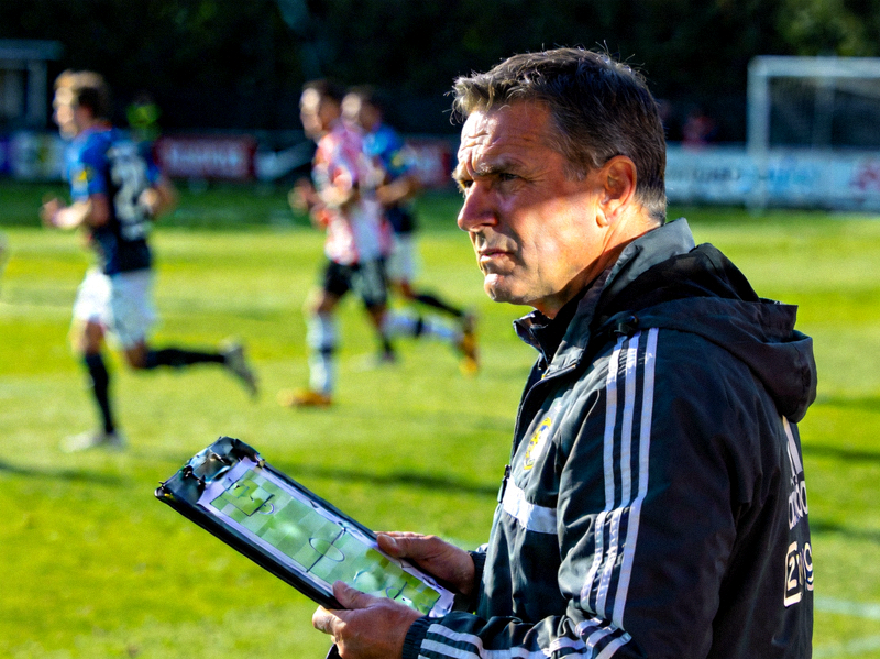 足球教练在场边专注指挥球队战术的严肃表情